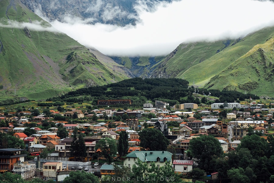 The town of Stepantsminda sits in a green valley below the Caucasus mountains in Georgia.