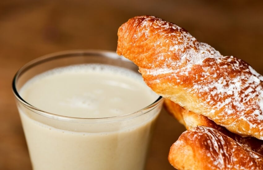 A glass of horchata served with fartons for breakfast in Spain.