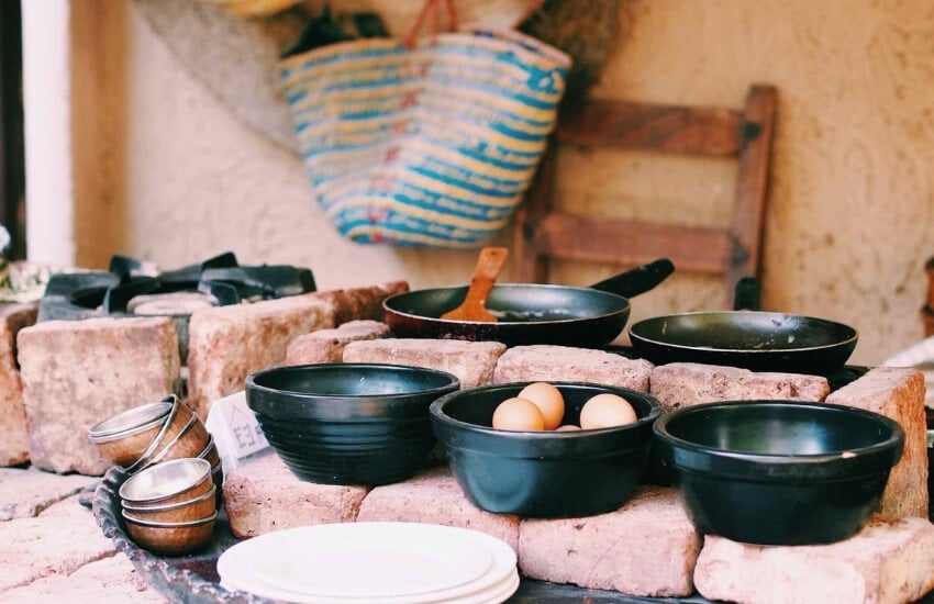 Pans and dishes arranged in an outdoor kitchen at Kargeen Cafe in Muscat, Oman.