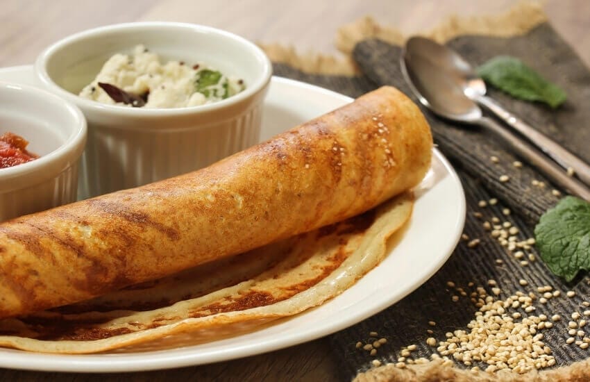 A thin Indian dosa pancake served with chilli and other accompaniments.