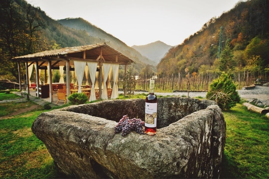 A winery in Adjara, with an outdoor seating around and mountains in the backdrop.