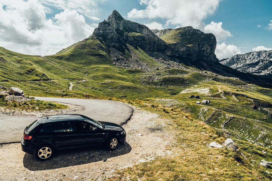 A black car parked in the mountains of Montenegro.