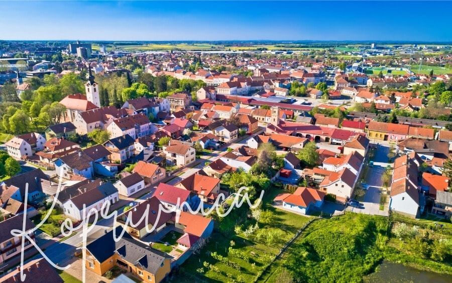 Red roofed houses set amongst a green landscape in the city of Koprivnica.