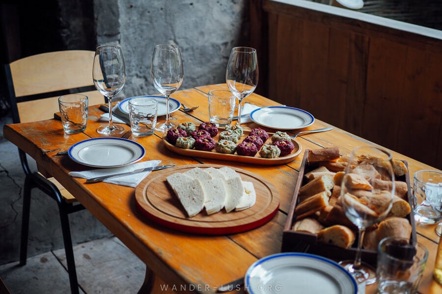 A generous spread of wine, cheese and bread on a wooden table at a winery in Kakheti, Georgia.