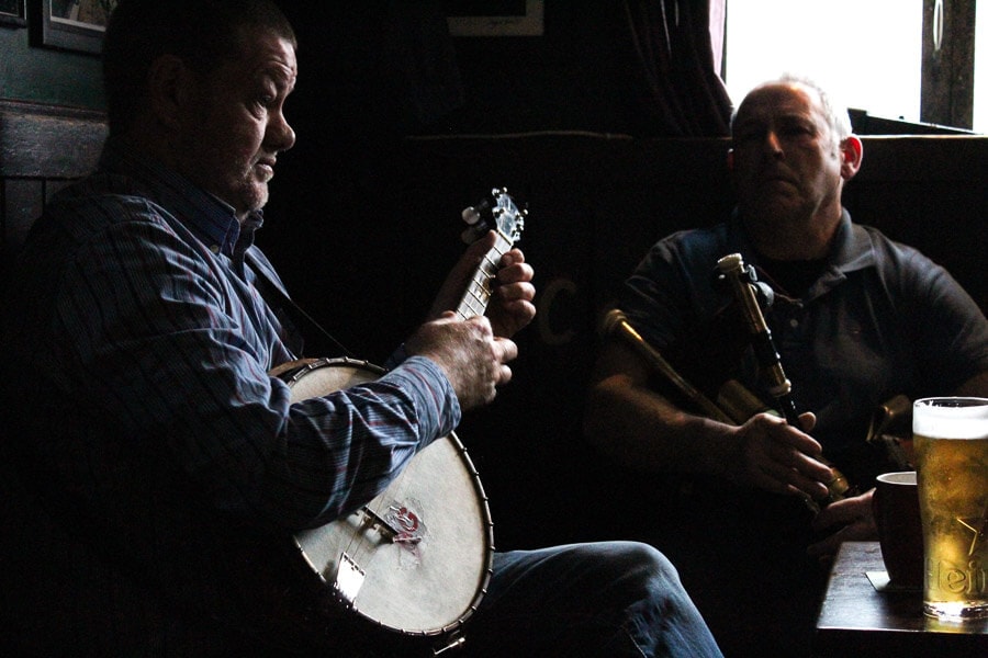 Two men play Irish music on traditional stringed instruments.