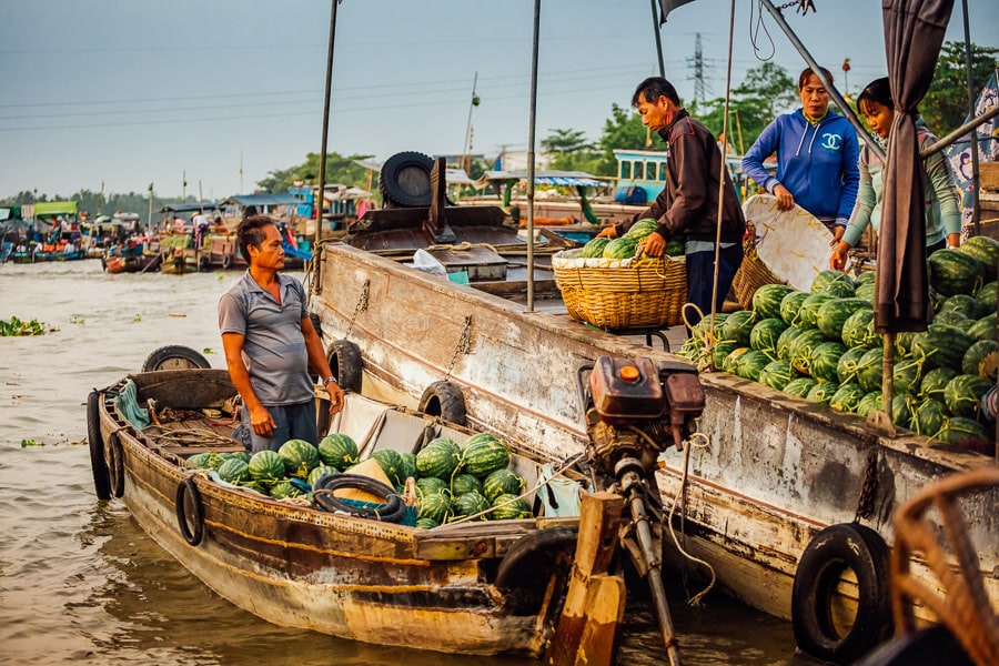 Men unload watermelons and other fruit at a floating market in Can Tho, Vietnam.