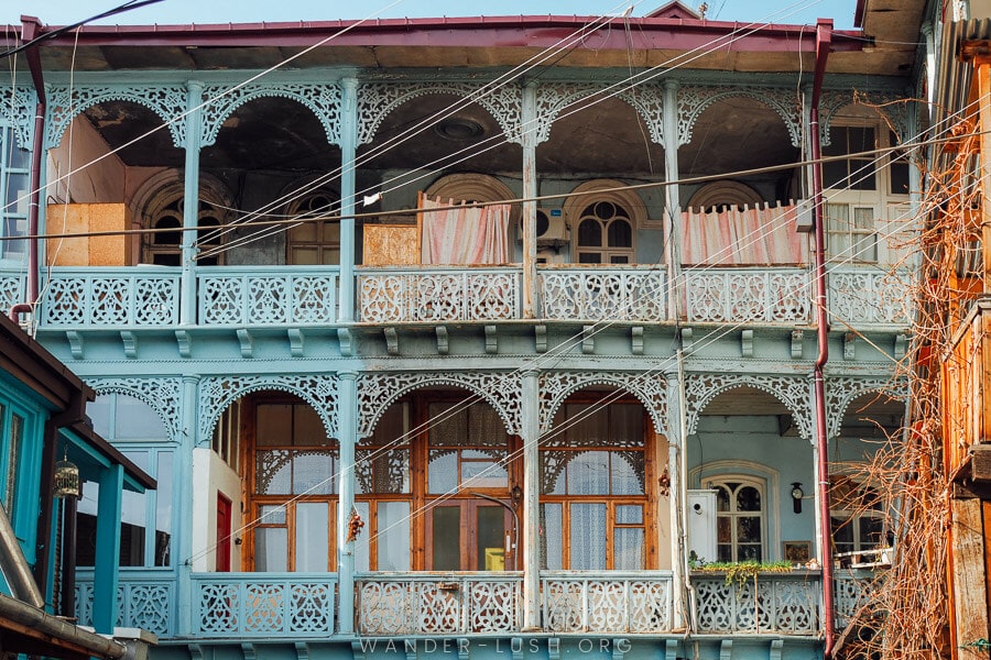 The Blue House, a grand two-story house with a carved wooden balcony in Tbilisi Old Town.