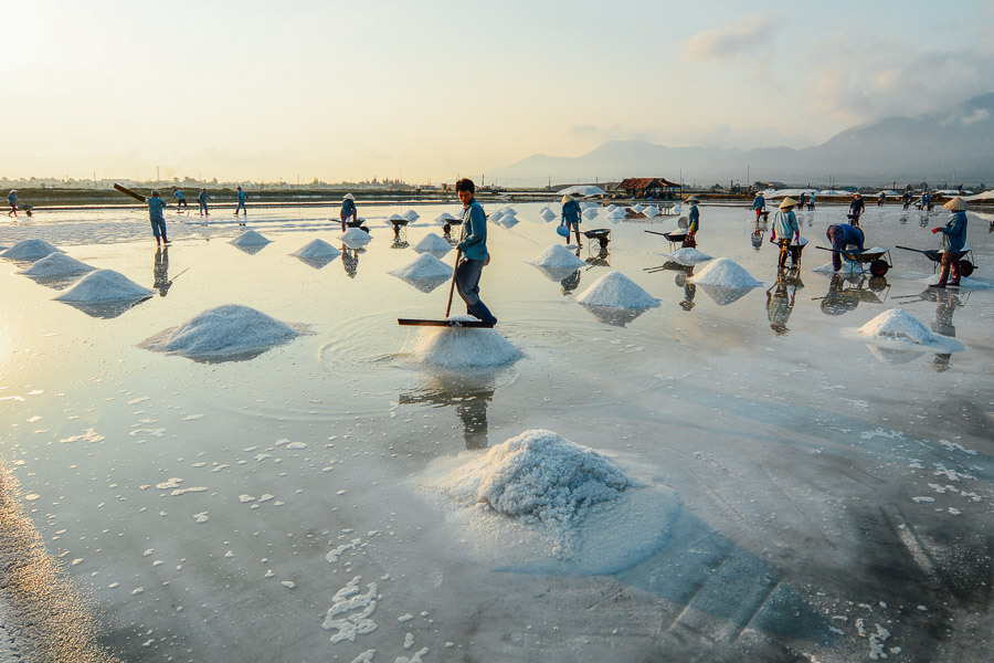 Workers toil on the salt pans in Vietnam.