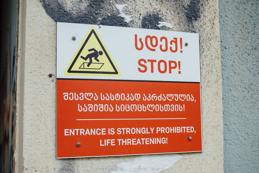 A sign warns people of dangerous conditions inside an abandoned bathhouse in Tskaltubo.