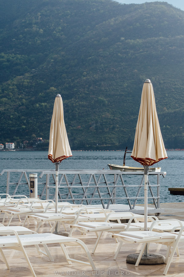 Umbrellas and deck chairs on the waterfront in Perast.