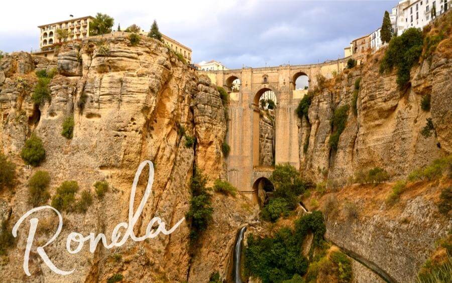 An impressive stone bridge stretches over a gorge in Ronda, Spain.