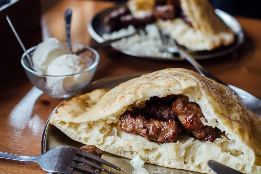 Classic Bosnian cevapi with somun, onion and kaymak on the side.