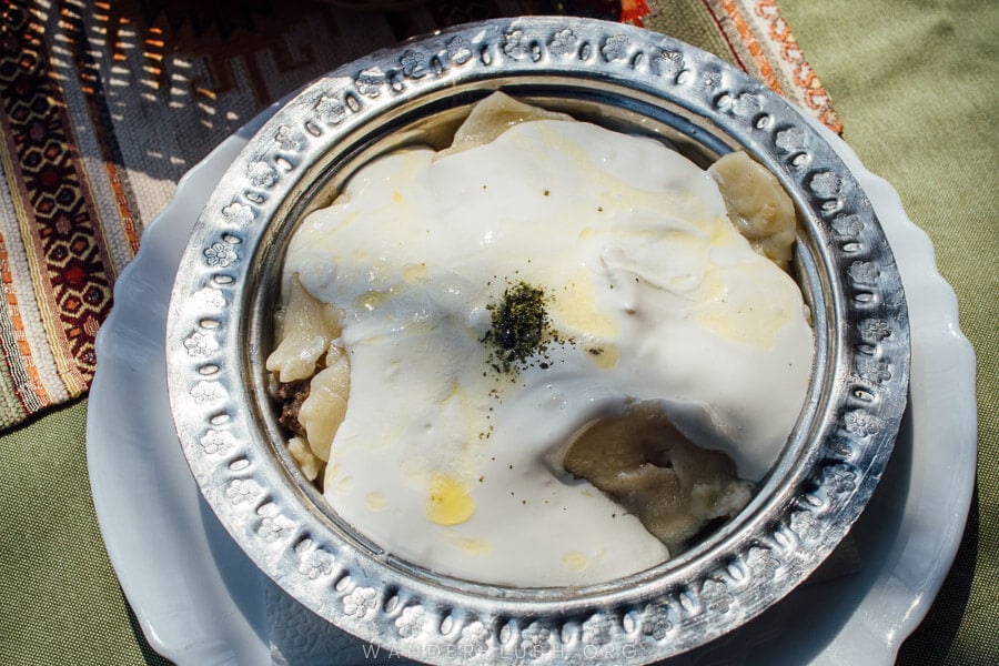 A plate of Bosnian dumplings, klepe, covered in sour cream at a restaurant in Mostar.