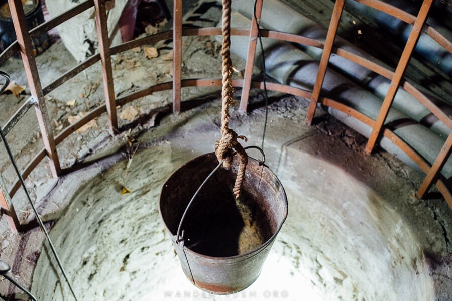 A steel bucket on a rope hangs over an empty well at the Stalin Printing Press House Museum in Tbilisi.