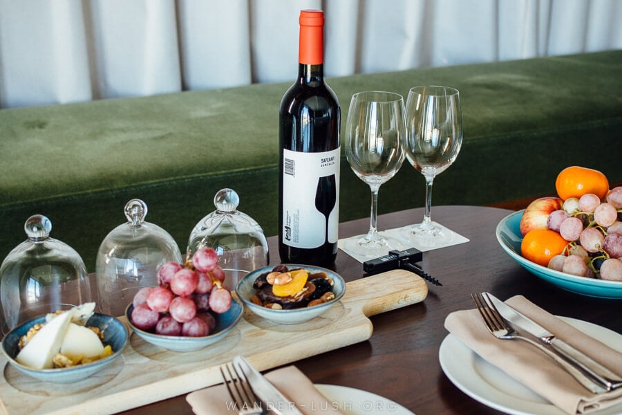 A spread of wine, fruit and cheese.