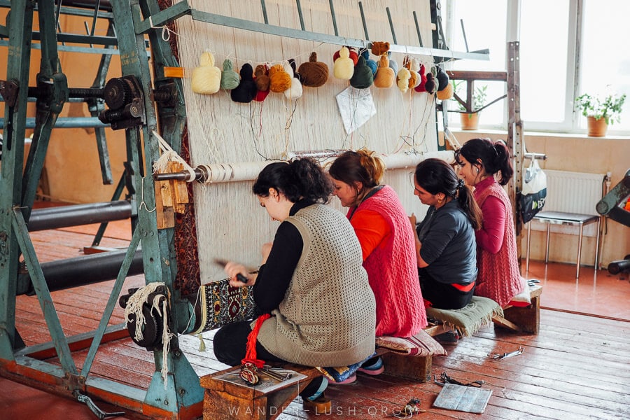 Women weave a large carpet at a workshop in Quba, Azerbaijan.