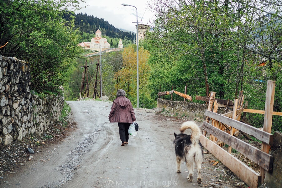 A woman walking down a road in a village in Svaneti, Georgia.