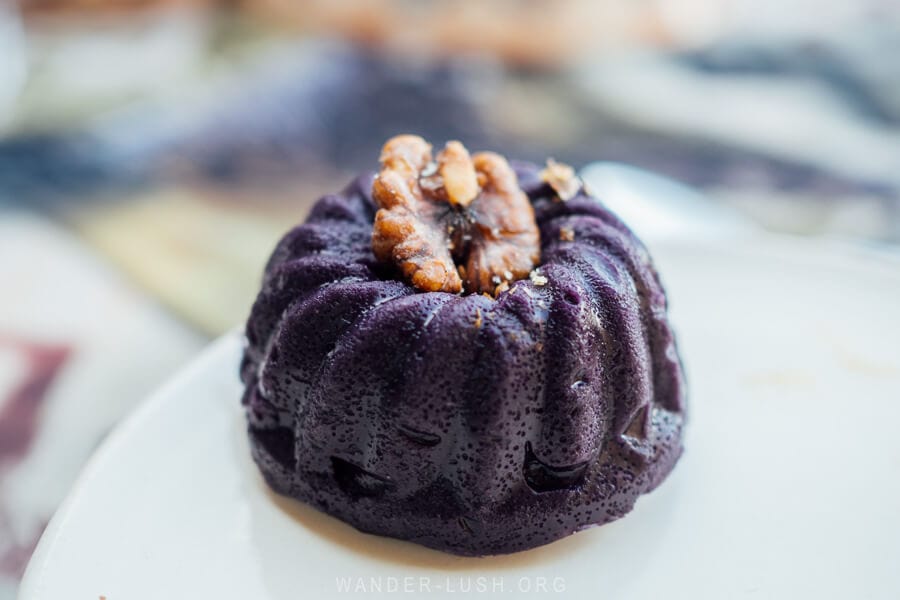 A small round purple Tatara pudding, a traditional Georgian grape dessert decorated with a walnut.