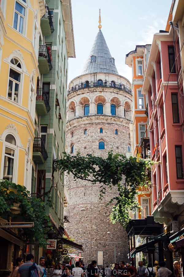 The Galata Tower in Istanbul sandwiched between colourful apartment buildings.