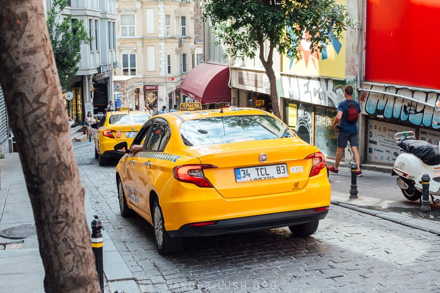 A yellow taxi on a steep street in Istanbul's Galata district.