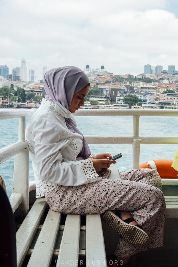 A woman using her phone on the ferry in Istanbul.