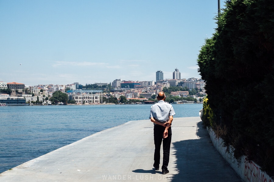 A lone man walks along the waterfront in Istanbul's Balat Sahil Park.