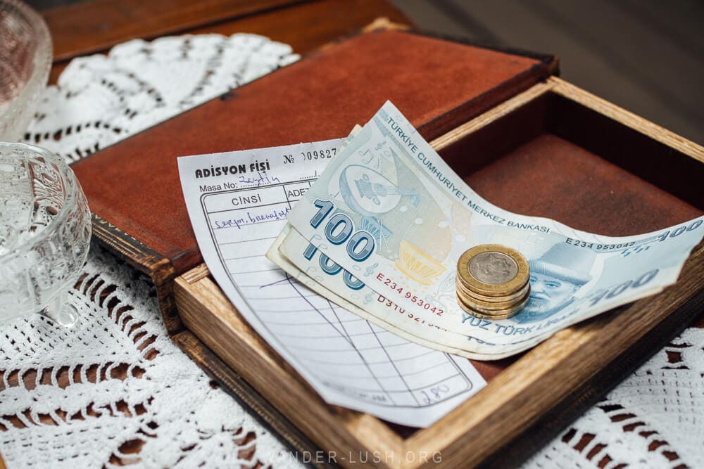 100 Turkish lira notes and coins on a cafe table in Istanbul.