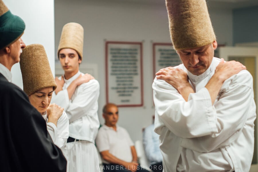 Whirling Dervishes dressed in white robes and tall hats.