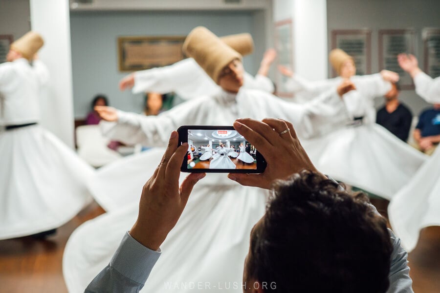 A man films Dervishes at a traditional Sema ceremony at a local mosque in Istanbul, Turkey.