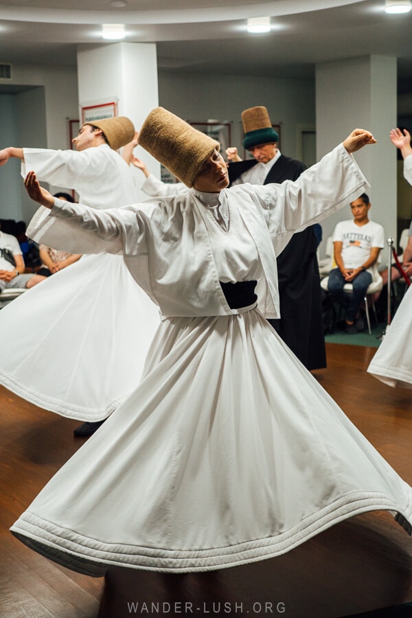 Whirling Dervishes twirl on a small stage at a local mosque in Istanbul, Turkey.