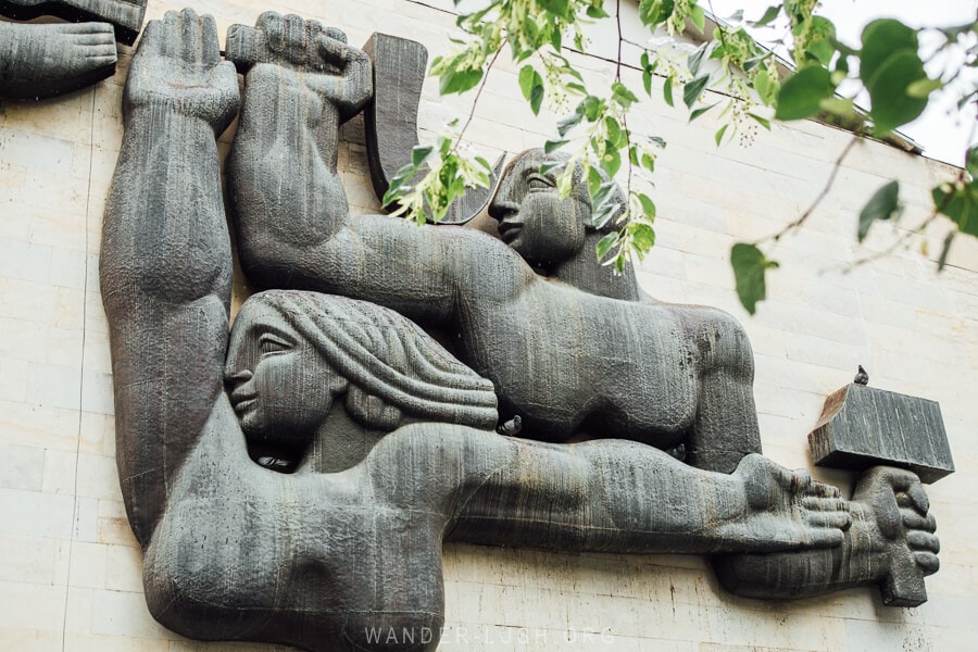 A Soviet-style monument showing a man and woman with hammer and sickle on a building in Borjomi.