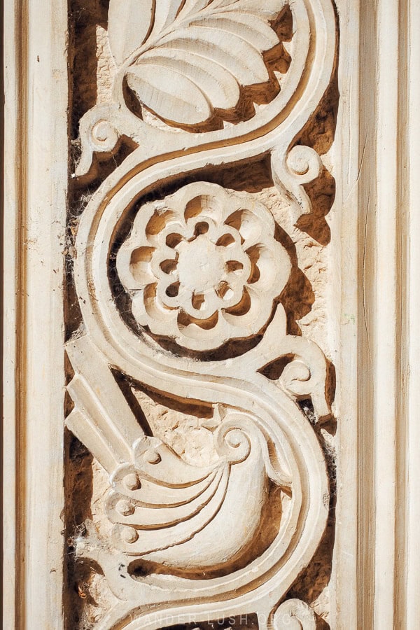 Detailed yellow stone engravings on the facade of an abandoned sanatorium hotel in Georgia.