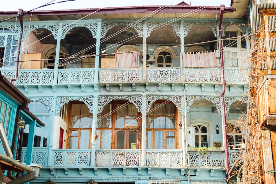 The Blue House, a grand two-story house with a carved wooden balcony in Tbilisi Old Town.