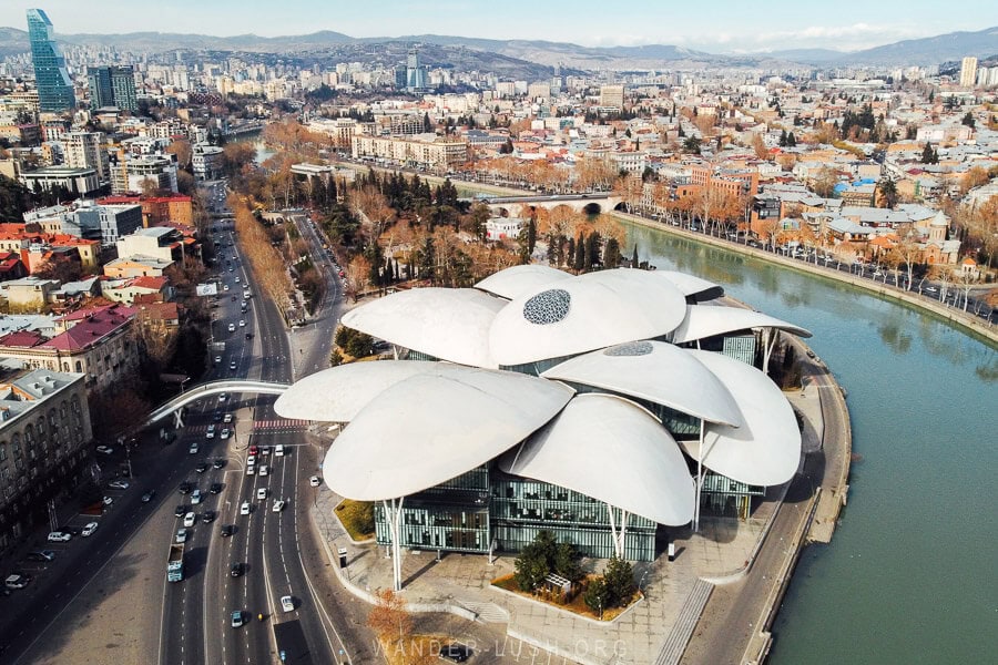 Aerial view of the Tbilisi Justice House, with the building's mushroom shaped roof visible alongside the Mtkvari River.
