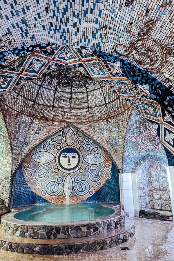 The interior of a Soviet-era bathhouse in Tbilisi, Georgia, with a face depicted in a mosaic decoration.