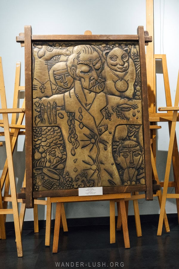 An easel holds a metal panel with a portrait of Niko Pirosmani at his house museum in Tbilisi.