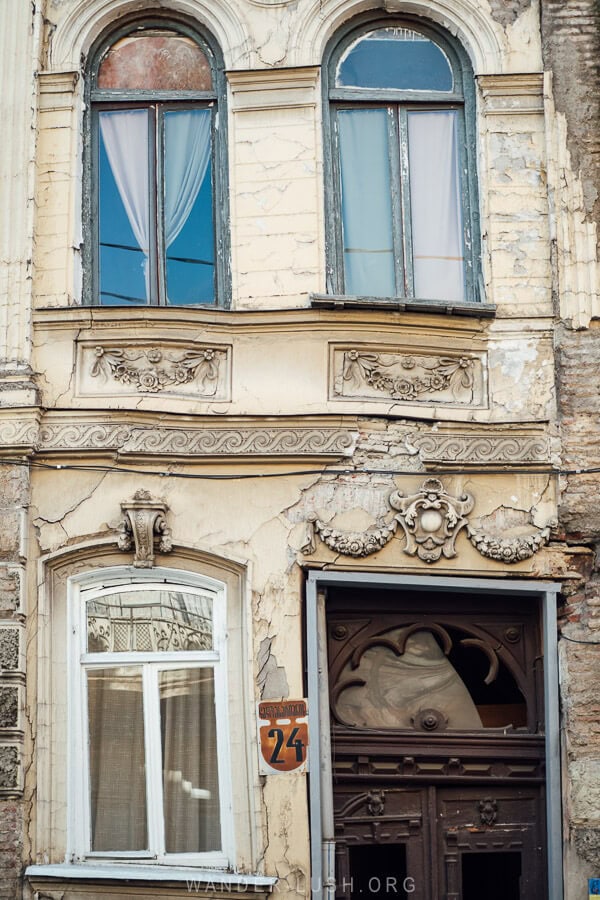 An old building with decorative elements cracks and buckles from old age in the Sololaki neighbourhood of Tbilisi.
