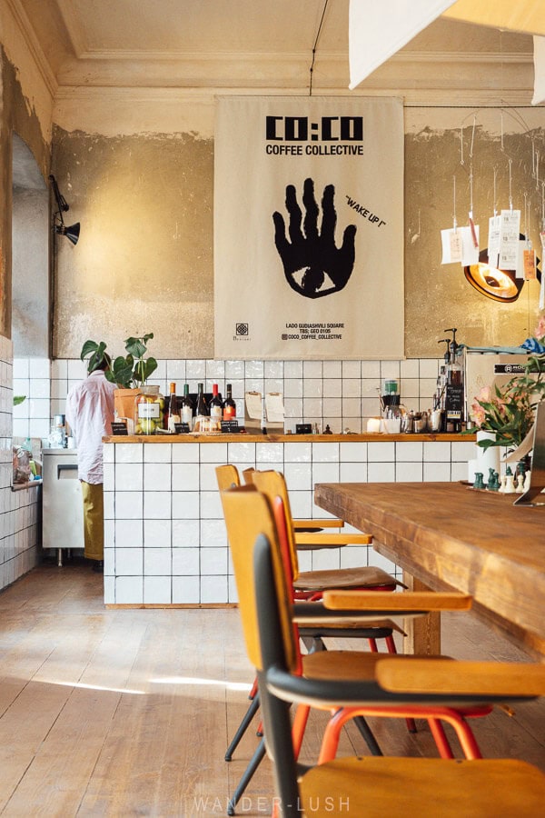 A contemporary cafe in Tbilisi, with a tiled bar and a poster above the bar.