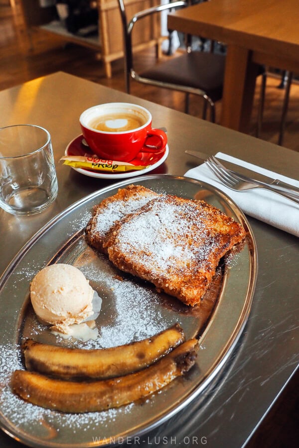 A silver plate of French Toast served with grilled banana and ice cream at a cafe in Tbilisi.