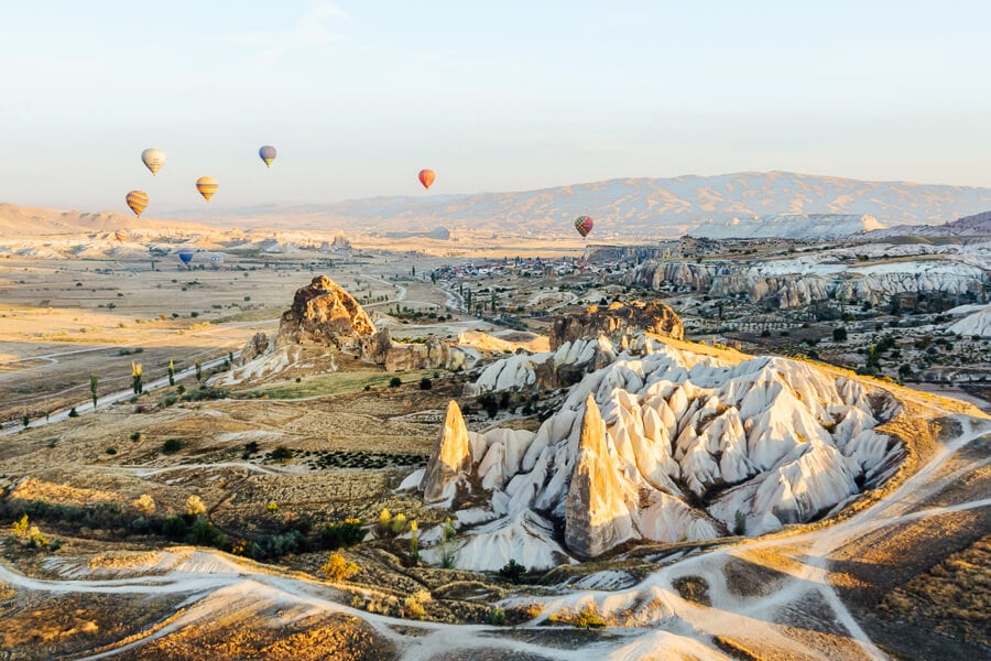 Balloons float over rock formations in the stunning Cappadocia region of Turkey.