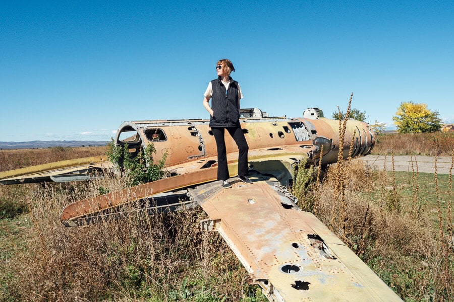 A woman stands on the wing of an abandoned Soviet plane in Big Shiraki, Georgia.