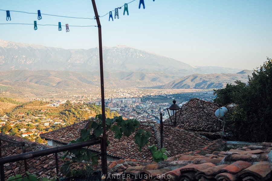 View of the city of Berat fringed by mountains with the red roofs of old houses and a washing line in the foreground.