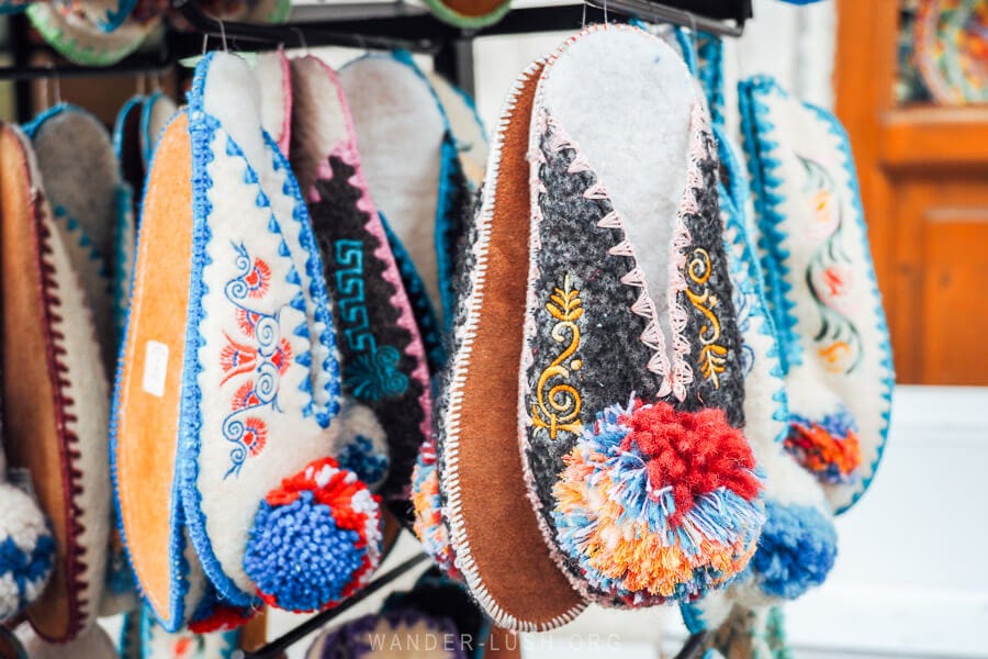 Woollen slippers with traditional decorations and pom poms for sale inside the bazaar in Gjirokaster, Albania.
