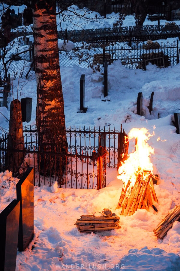 A flame lit next to gravestones in a small cemetery in Mestia, Georgia.