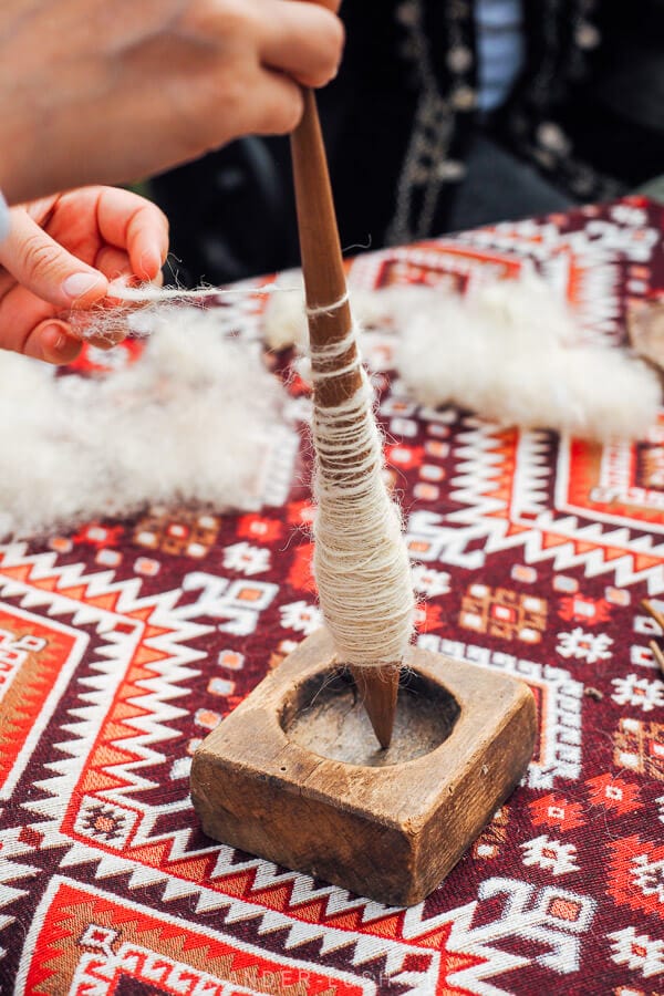 A person spins wool at a Tusheti Festival in Georgia.