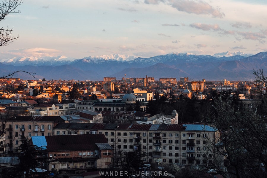 Kutaisi, a city in Georgia with low-rise buildings and a backdrop of snowcapped mountains, the Lesser Caucasus. 