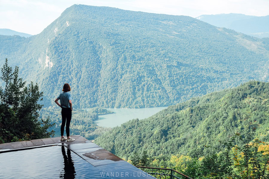 A woman standing on the edge of a freshwater pool in the mountains of Georgia, Lailashi Secret Pool in Lechkhumi.