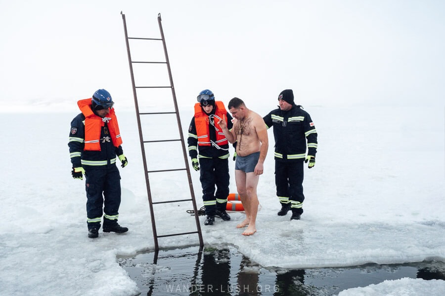 A man prepares to descend a ladder into the frozen Paravani Lake on Orthodox Epiphany in Georgia.