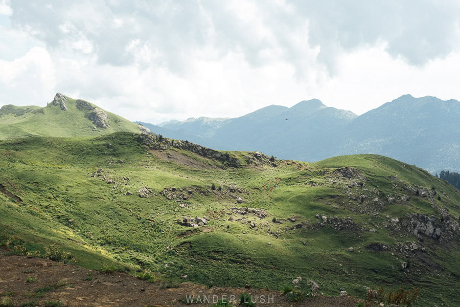 Green hills dappled with light and shadow at the peak of the Zekari Pass between Baghdati and Abastumani in Georgia.