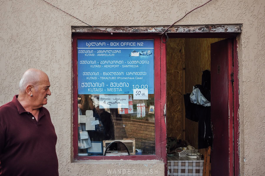 A ticket window with blue signage at the bus station in Kutaisi with information about the Kutaisi Mestia bus.